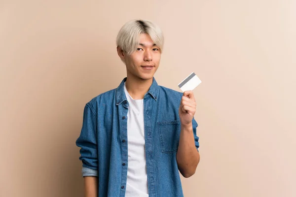 Fiatal Ázsiai Férfi Elszigetelt Háttér Kezében Egy Hitelkártya — Stock Fotó