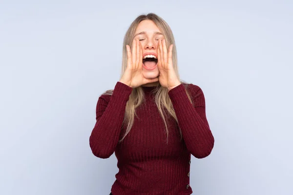 Joven Rubia Sobre Fondo Azul Aislado Gritando Anunciando Algo —  Fotos de Stock