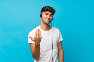 Soyutlanmış mavi geçmişi olan genç yakışıklı bir adam kulaklıkla çalışıyor.