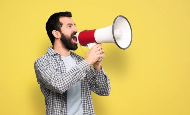 Handsome man with beard shouting through a megaphone