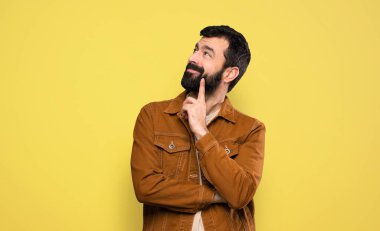 Sakallı yakışıklı adam yukarı bakarken bir fikir düşünüyor.