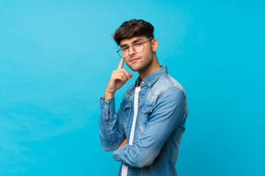 Gözlüklü, soyutlanmış, mavi bir geçmişi olan yakışıklı bir adam.