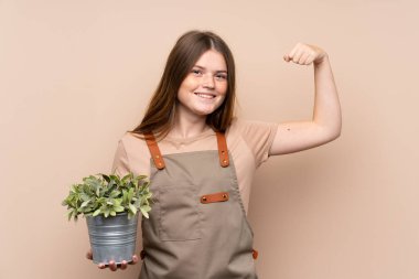 Ukraynalı genç bahçıvan kız elinde zaferi kutlayan bir bitki tutuyor.