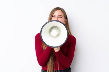 İzole edilmiş beyaz arka planda genç sarışın kız megafondan bağırıyor.