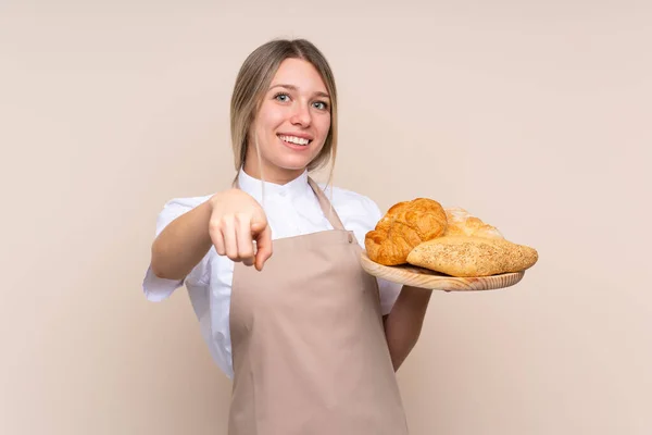 Młoda Blondynka Fartuchu Kobieta Piekarz Trzyma Stół Kilkoma Pieczywem Wskazuje — Zdjęcie stockowe