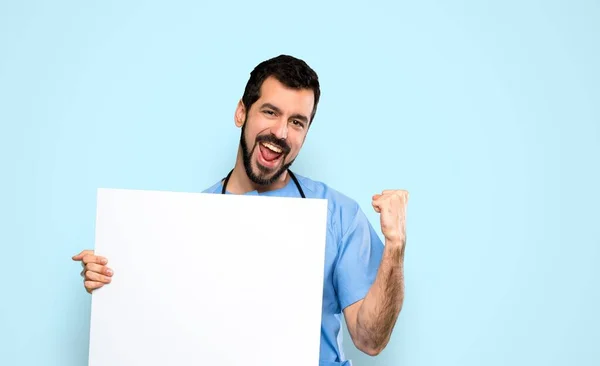 Cirujano Doctor Hombre Sosteniendo Cartel Vacío Sobre Fondo Azul Aislado —  Fotos de Stock