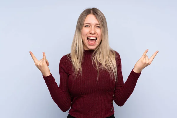 Jovem Mulher Loira Sobre Fundo Azul Isolado Fazendo Gesto Rock — Fotografia de Stock