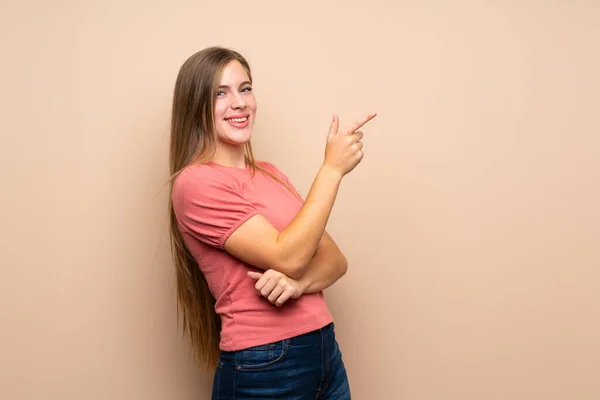 Teenager Blondýny Dívka Přes Izolované Pozadí Ukazující Prstem Stranu — Stock fotografie