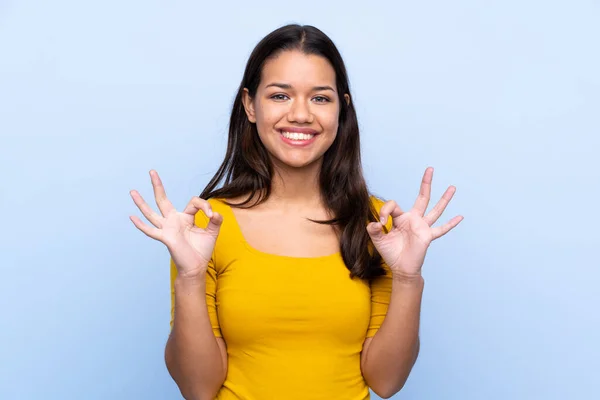 Menina Colombiana Sobre Fundo Azul Isolado Mostrando Sinal Com Dedos — Fotografia de Stock