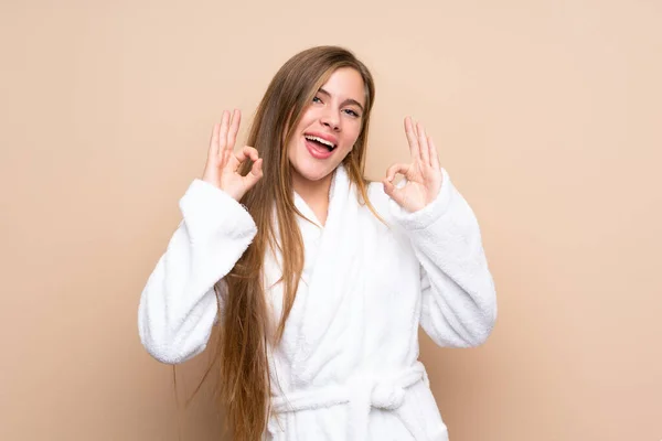 Teenager Mädchen Einem Bademantel Über Isoliertem Hintergrund Zeigt Ein Zeichen — Stockfoto