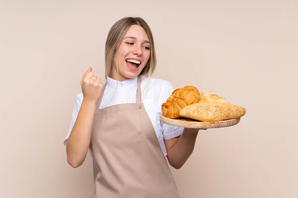 Młoda Blondynka Fartuchu Kobieta Piekarz Trzyma Stół Kilkoma Chlebami Świętując — Zdjęcie stockowe