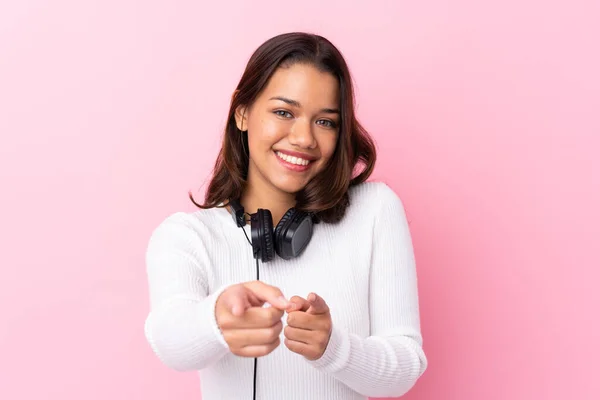 Mujer Joven Con Auriculares Sobre Aislados Puntos Pared Rosa Dedo —  Fotos de Stock