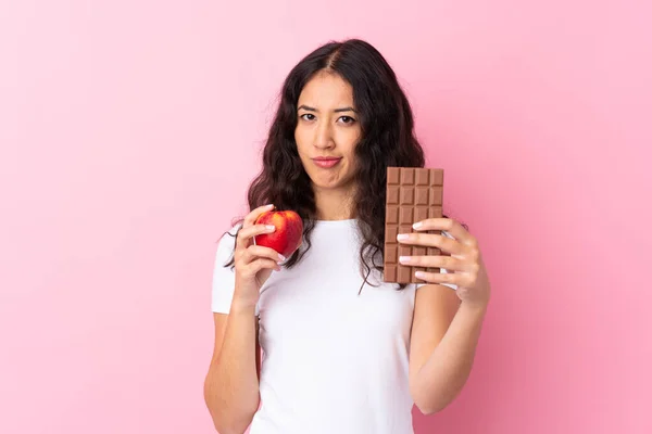 Španělská Číňanka Přes Izolované Růžové Pozadí Čokoládovou Tabletu Jedné Ruce — Stock fotografie