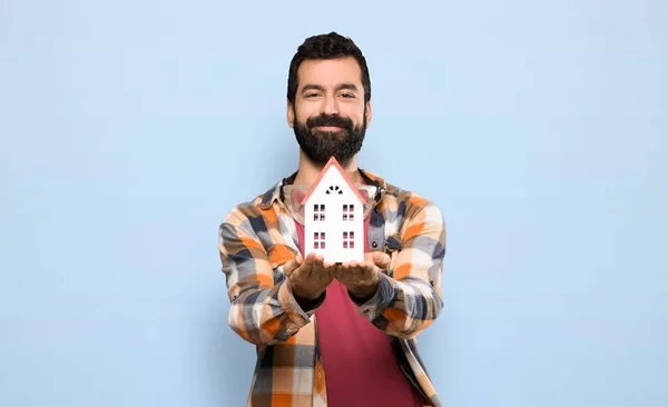 Artesanos Sosteniendo Una Casita Sobre Fondo Azul Aislado — Foto de Stock