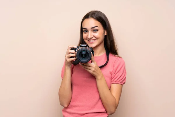 Mujer Joven Sobre Fondo Aislado Con Una Cámara Profesional — Foto de Stock