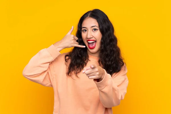 Spaanse Chinese Vrouw Geïsoleerde Gele Achtergrond Maken Telefoon Gebaar Wijzen — Stockfoto