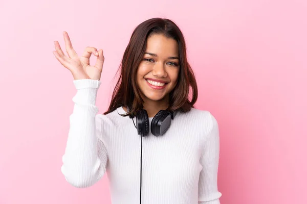 Mujer Joven Con Auriculares Sobre Pared Rosa Aislada Que Muestra —  Fotos de Stock