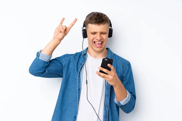 Молодой Красивый Мужчина Изолированном Белом Фоне Помощью Мобильного Телефона Наушниками — стоковое фото