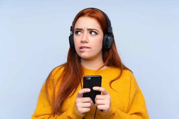 Rousse Adolescent Fille Sur Isolé Bleu Fond Écoute Musique Avec — Photo