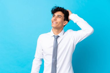 Arjantinli genç işadamı mavi arka planda gülüyor.