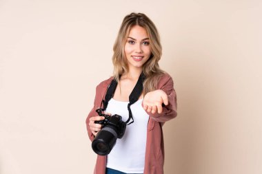 Arka planda izole edilmiş genç fotoğrafçı kız bir ilan vermek için avucunun içinde hayali bir alan tutuyor.