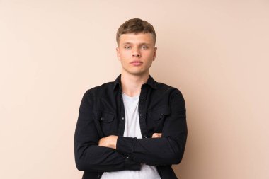 Genç yakışıklı adam kollarını kavuşturuyor.