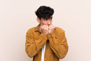 Arjantinli genç bir adam izole edilmiş arka planda gergin ve korkmuş halde elleriyle suni teneffüs yapıyor.