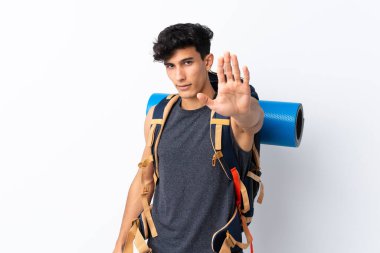 Arjantinli genç yürüyüşçü beyaz arka planda, eliyle durdurma hareketi yapıyor.