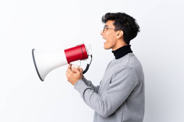 Arjantinli genç adam izole edilmiş beyaz arka planda megafondan bağırıyor.