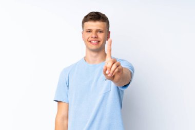 Soyutlanmış beyaz arka planda genç yakışıklı adam parmağını kaldırıyor ve gösteriyor.