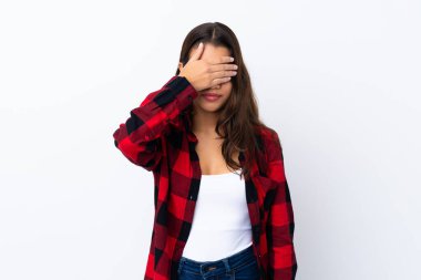 İzole edilmiş beyaz bir geçmişi olan genç Kolombiyalı kız elleriyle gözlerini kapatıyor.