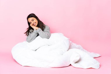 Yerde pijama giyen melez bir kadın avuç içlerini bir arada tutuyor. İnsan bir şey ister.