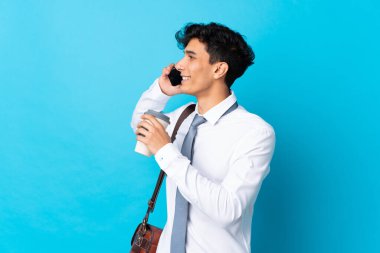 Genç Arjantinli iş adamı mavi arka planda.