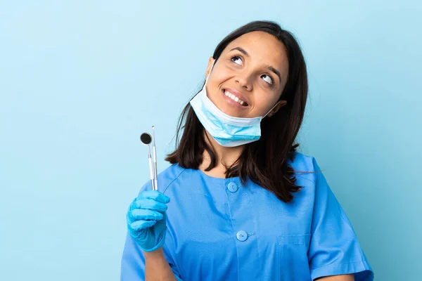 Junge Brünette Zahnärztin Mit Gemischter Rasse Hält Werkzeuge Über Isolierten — Stockfoto