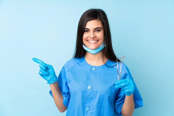 Mladá Žena Zubař Drží Nástroje Přes Izolované Modré Pozadí Ukazující — Stock fotografie