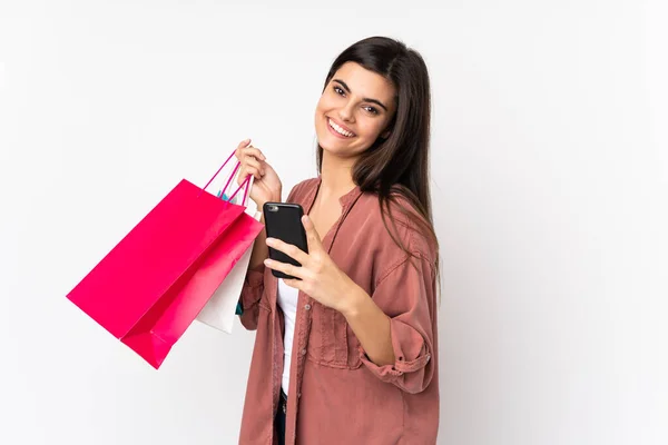 Ung Kvinna Över Isolerad Vit Bakgrund Hålla Shoppingväskor Och Skriva — Stockfoto