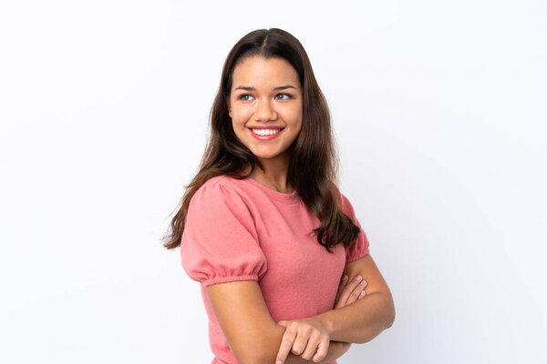 Young Colombian girl over isolated white background with arms crossed and happy