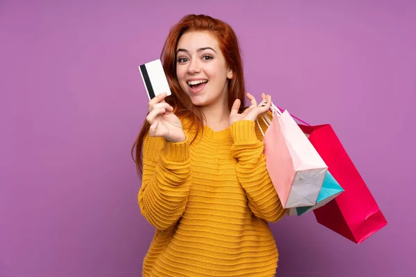 소녀가 쇼핑백과 카드를 보라색 배경을 가지고 — 스톡 사진