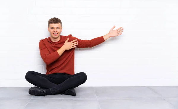 Jonge Knappe Man Zit Vloer Handen Uit Strekken Naar Zijkant — Stockfoto