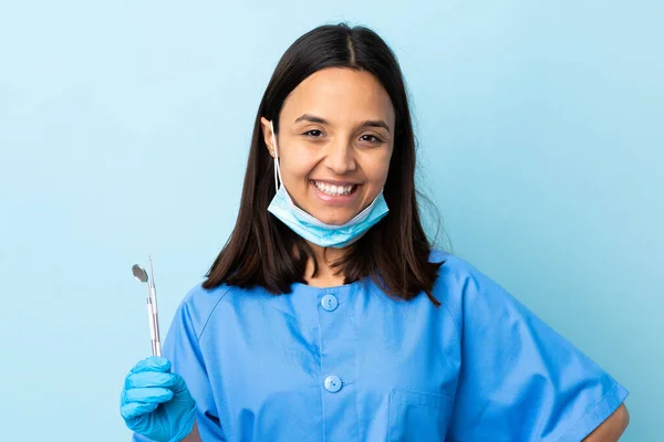 若いですブルネット混合レース歯科医女性保持ツール上の隔離された背景Posing上の腕でヒップと笑顔 — ストック写真