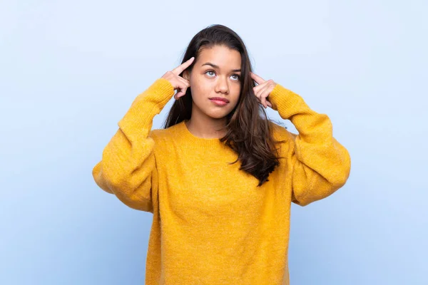 Giovane Ragazza Colombiana Con Maglione Sfondo Blu Isolato Avendo Dubbi — Foto Stock