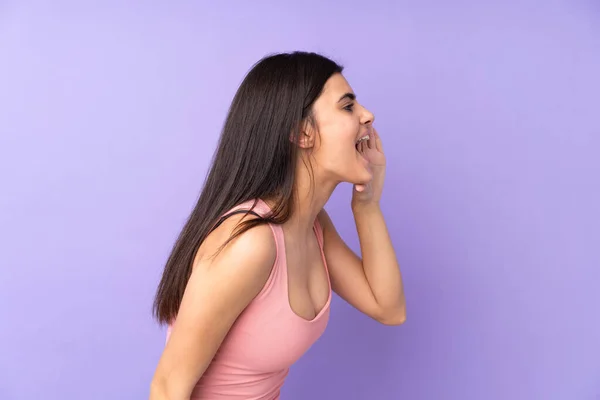 Młoda Kobieta Nad Odizolowanym Fioletowym Tle Krzyczy Szeroko Otwartymi Ustami — Zdjęcie stockowe