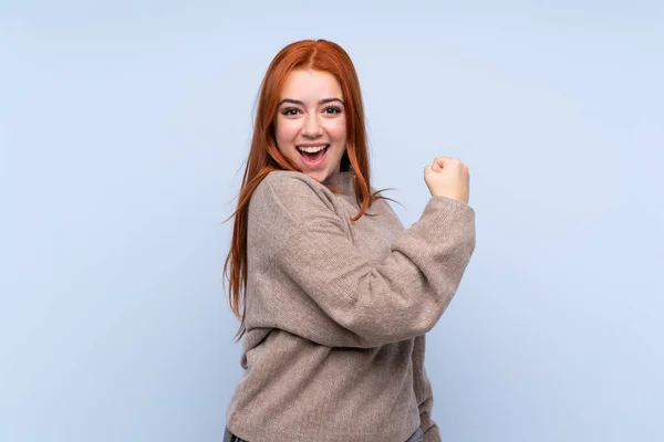 Ragazza Adolescente Rossa Con Maglione Sfondo Blu Isolato Che Celebra — Foto Stock