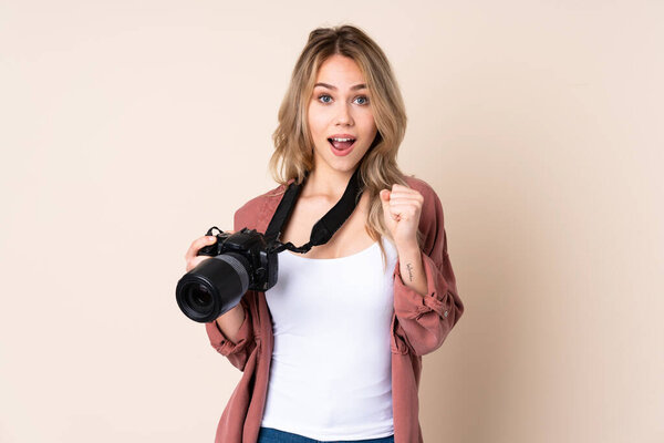 Девушка-фотограф на изолированном фоне празднует победу на позиции победителя
