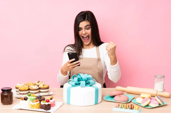 Konditor Mit Einem Großen Kuchen Einem Tisch Über Isoliertem Rosa — Stockfoto