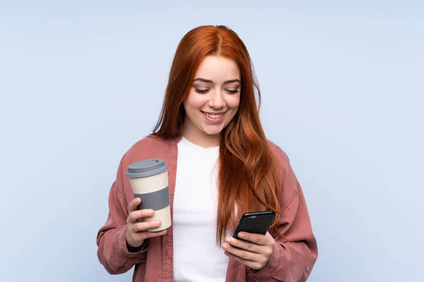 Redhead Έφηβος Κορίτσι Πάνω Από Απομονωμένο Μπλε Φόντο Κρατώντας Καφέ — Φωτογραφία Αρχείου