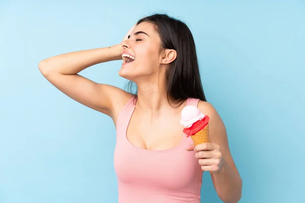 Young woman holding a cornet ice cream over isolated blue background has realized something and intending the solution