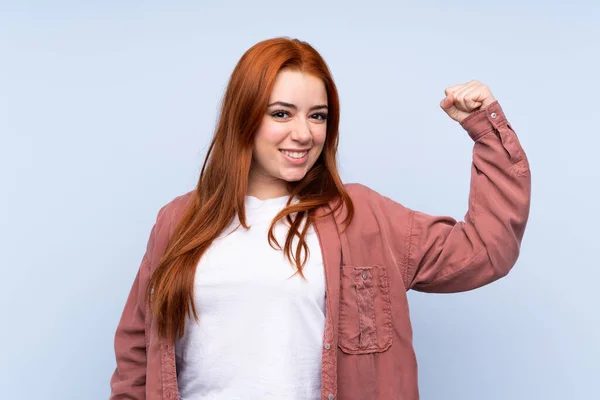 Rossa Adolescente Ragazza Isolato Sfondo Blu Facendo Forte Gesto — Foto Stock