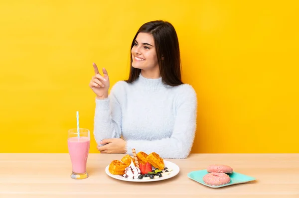 Mujer Joven Comiendo Gofres Batido Una Mesa Sobre Fondo Amarillo —  Fotos de Stock