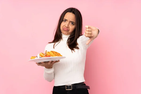 Jovem Morena Segurando Waffles Sobre Fundo Rosa Isolado Mostrando Polegar — Fotografia de Stock